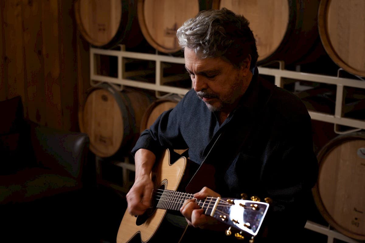 Jarrett Renshaw playing acoustic guitar